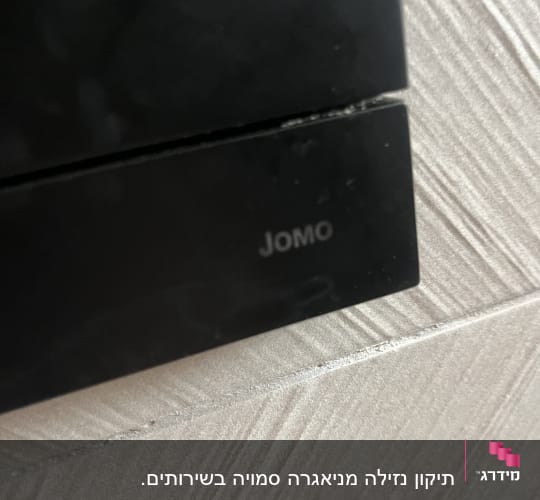 צילום תקריב של לחצן הפעלה שחור לניאגרה סמויה מתוצרת JOMO